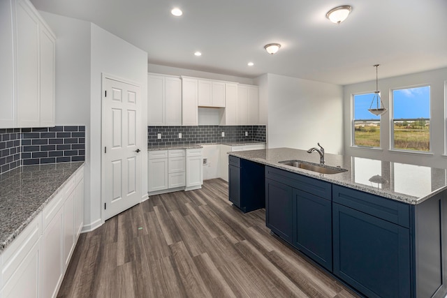 kitchen with white cabinetry, sink, dark wood-type flooring, tasteful backsplash, and pendant lighting