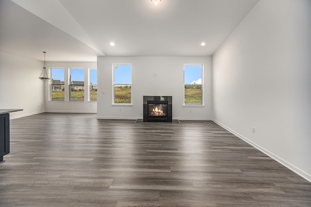 unfurnished living room with dark wood-type flooring and vaulted ceiling