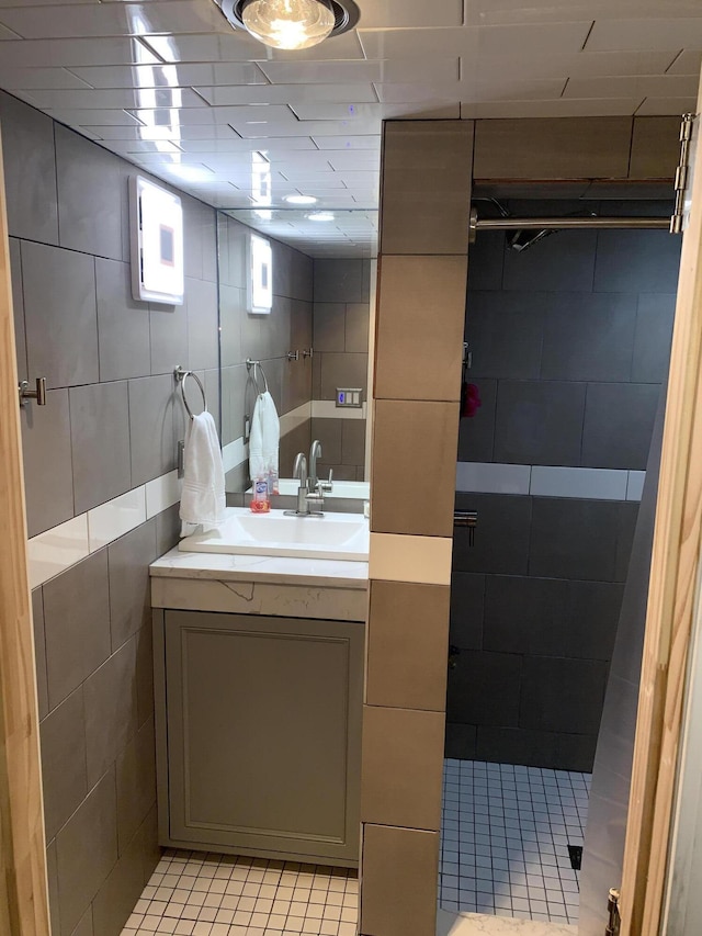 bathroom with tile patterned flooring, vanity, and tile walls