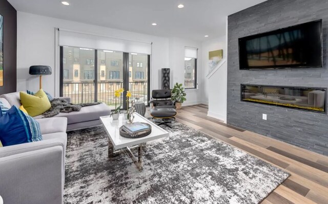 living room featuring a large fireplace and light wood-type flooring