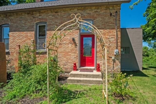 view of exterior entry featuring a yard