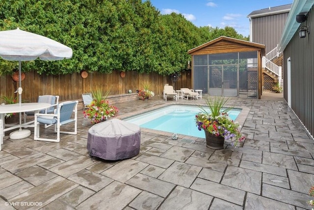 view of pool with grilling area, a patio area, and a sunroom