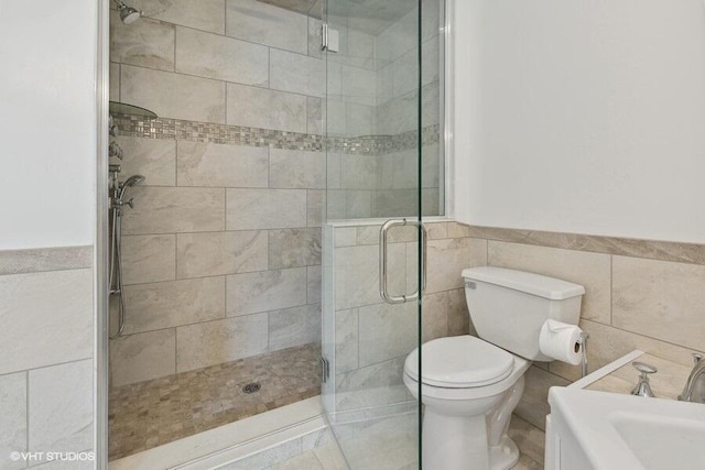 bathroom featuring toilet, tile walls, and walk in shower