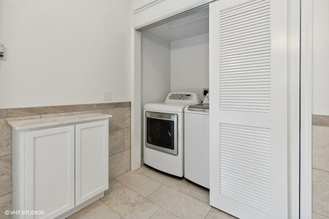 laundry room featuring washer and dryer, light tile patterned floors, and tile walls