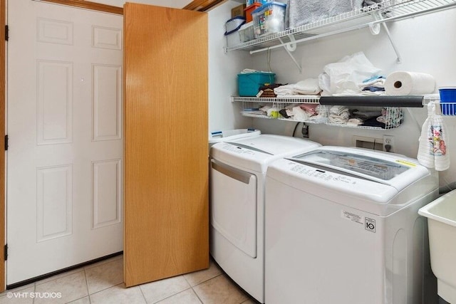 clothes washing area featuring washing machine and clothes dryer, sink, and light tile patterned flooring