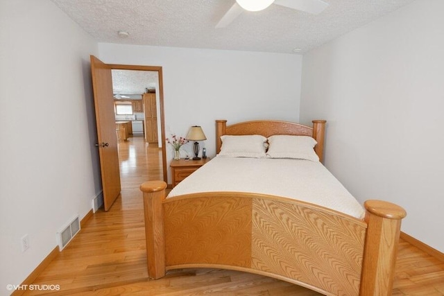 bedroom featuring ceiling fan, light hardwood / wood-style floors, and a textured ceiling