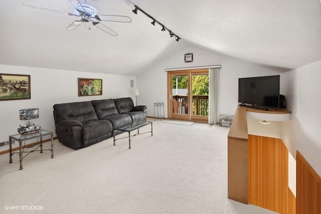 living room with a textured ceiling, carpet floors, ceiling fan, and lofted ceiling