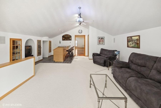 living room featuring ceiling fan, carpet floors, and vaulted ceiling