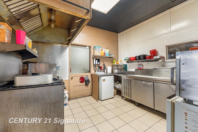 kitchen featuring fridge and light tile patterned flooring