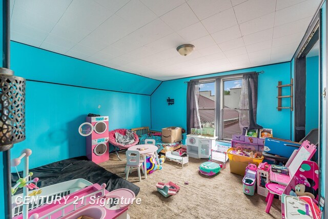 playroom with vaulted ceiling and carpet