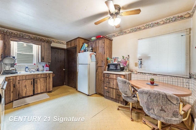 kitchen with white refrigerator, backsplash, and ceiling fan