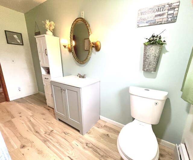 bathroom with wood-type flooring, vanity, and toilet