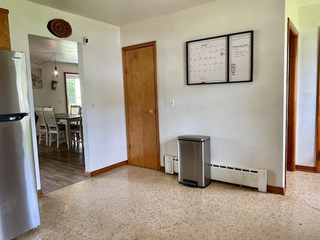 unfurnished room with a baseboard heating unit