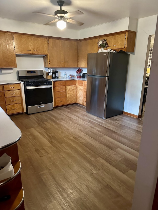 kitchen featuring ceiling fan, stainless steel appliances, and wood-type flooring