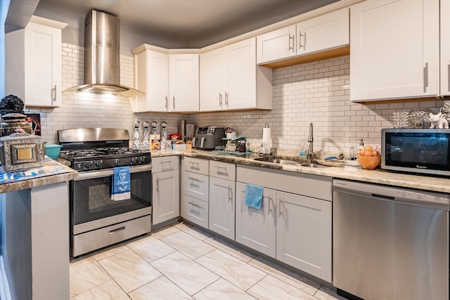 kitchen featuring sink, stainless steel appliances, tasteful backsplash, white cabinets, and wall chimney exhaust hood