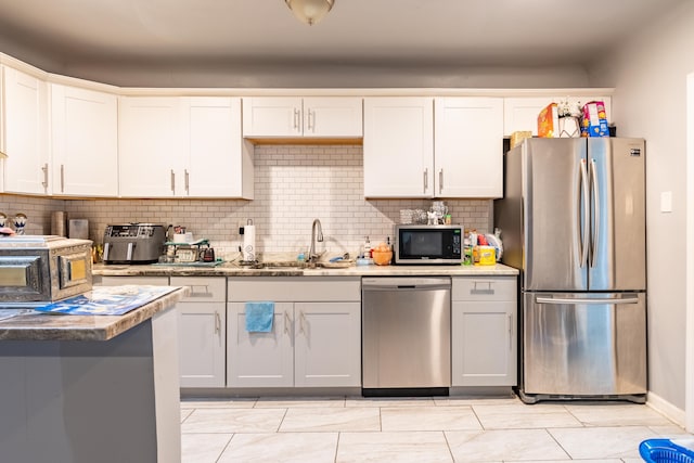 kitchen with sink, decorative backsplash, stainless steel appliances, and white cabinets