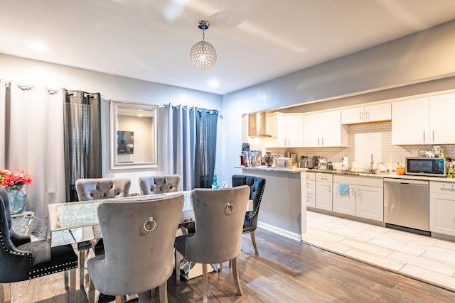 dining space with sink and light hardwood / wood-style floors