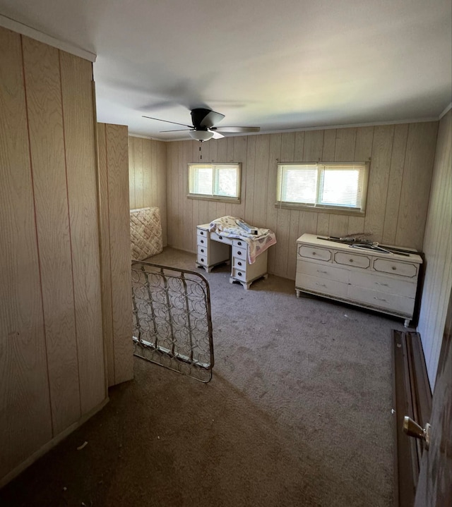 unfurnished bedroom featuring dark colored carpet, ceiling fan, and wood walls