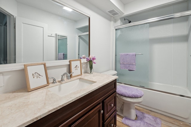 full bathroom with enclosed tub / shower combo, vanity, wood-type flooring, and toilet