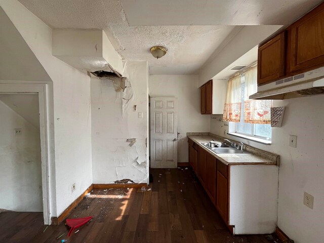 kitchen featuring a textured ceiling, dark hardwood / wood-style flooring, and sink