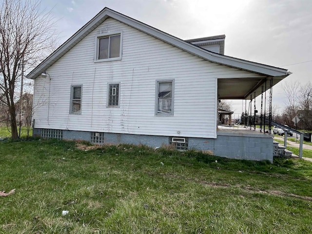 view of home's exterior with a lawn and covered porch