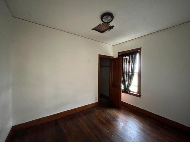 empty room with dark wood-type flooring