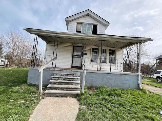 bungalow with covered porch and a front yard