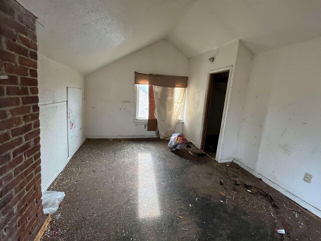 additional living space featuring lofted ceiling and a textured ceiling