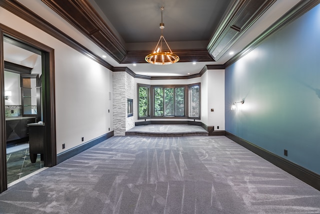 unfurnished room with dark carpet, a raised ceiling, and ornamental molding