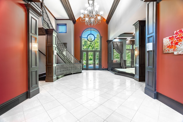 tiled entrance foyer with beamed ceiling, crown molding, a high ceiling, and an inviting chandelier