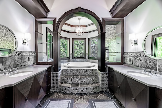 bathroom featuring a chandelier, ornamental molding, vanity, and a healthy amount of sunlight