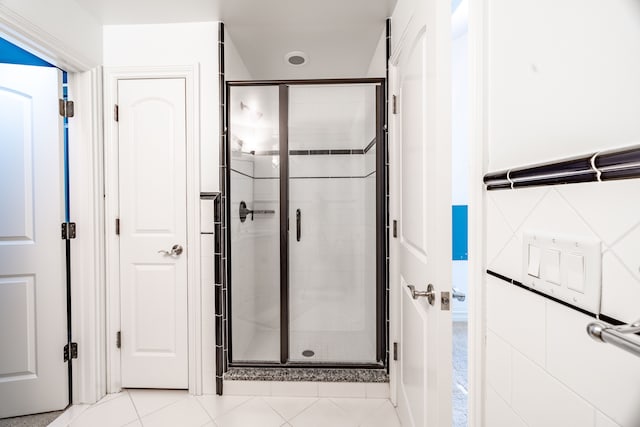 bathroom with tile patterned flooring and an enclosed shower