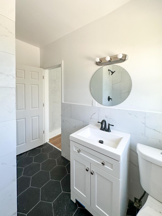 3737 Scovel Pl, Detroit, MI 48208 - bathroom featuring tile walls, vanity, toilet, tile patterned floors, and a wainscoted wall