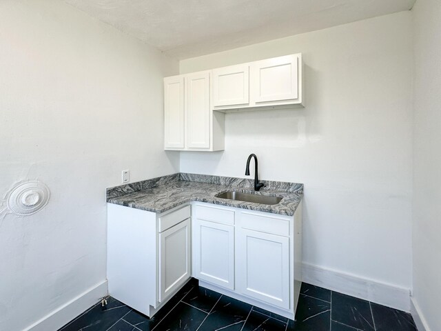 3737 Scovel Pl, Detroit, MI 48208 - kitchen with a sink, baseboards, white cabinetry, and dark tile patterned floors