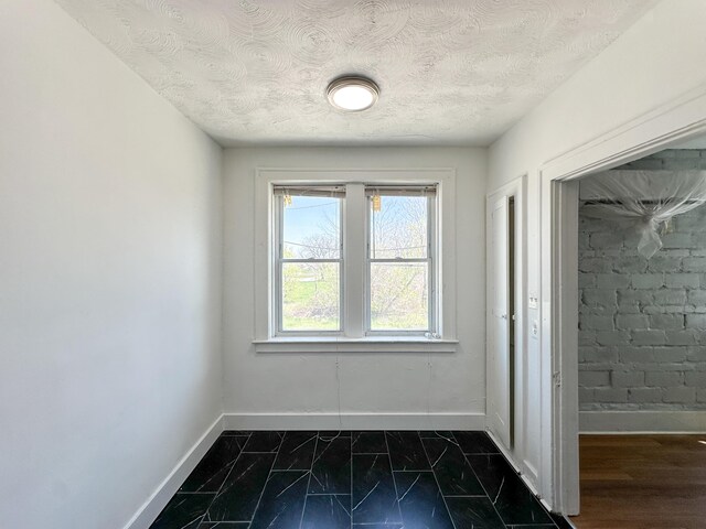 3737 Scovel Pl, Detroit, MI 48208 - empty room with baseboards, dark marble finish flooring, and a textured ceiling