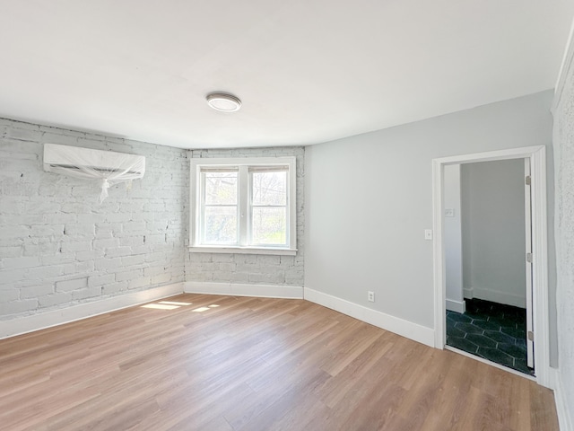 3737 Scovel Pl, Detroit, MI 48208 - unfurnished room featuring an AC wall unit, wood finished floors, and baseboards