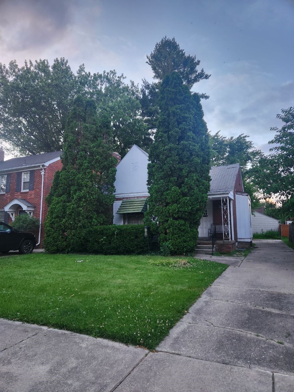 2048 Hunt Club Dr, Grosse Pointe Woods, MI 48236 - view of front facade with a front yard, brick siding, and a metal roof