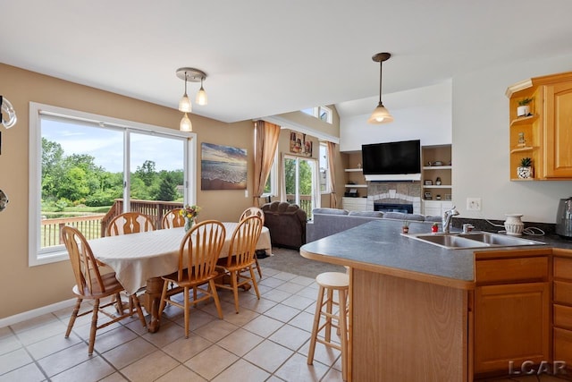 kitchen featuring a healthy amount of sunlight, light tile patterned floors, sink, and a breakfast bar area