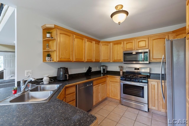 kitchen with light tile patterned flooring, stainless steel appliances, kitchen peninsula, and sink