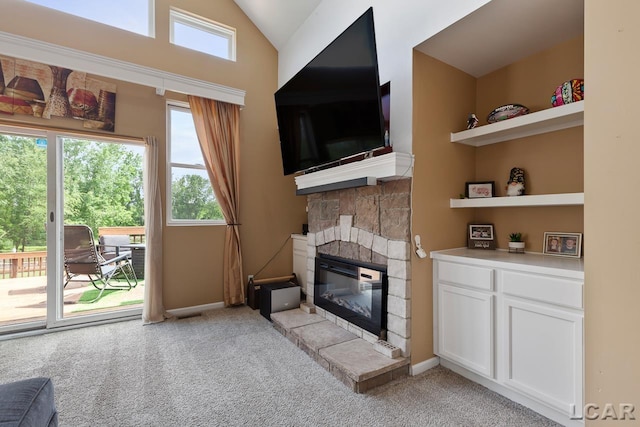 carpeted living room featuring a fireplace, a wealth of natural light, and vaulted ceiling