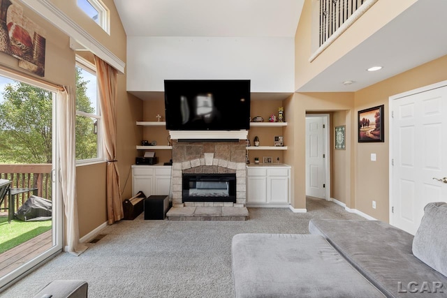 carpeted living room with a fireplace, a high ceiling, and built in shelves