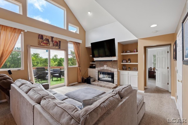 carpeted living room with plenty of natural light, built in features, a fireplace, and high vaulted ceiling