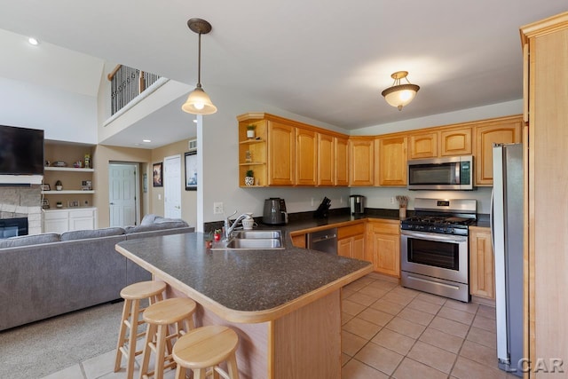 kitchen featuring pendant lighting, a breakfast bar, sink, appliances with stainless steel finishes, and kitchen peninsula