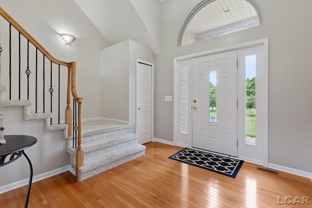 entryway featuring light hardwood / wood-style floors and high vaulted ceiling