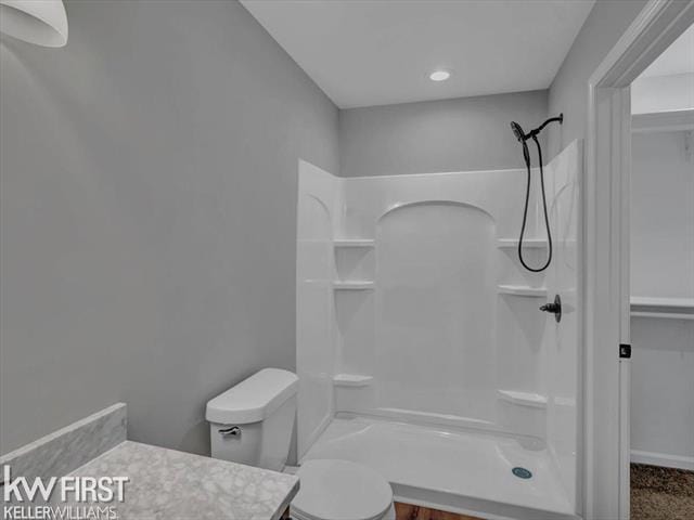 bathroom with vanity, toilet, and a shower