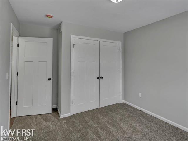 unfurnished bedroom with carpet floors and a closet