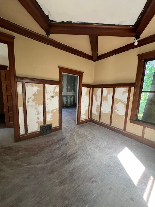 unfurnished living room with lofted ceiling with beams and ornamental molding