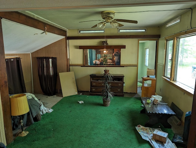 misc room with carpet flooring, wooden walls, and vaulted ceiling