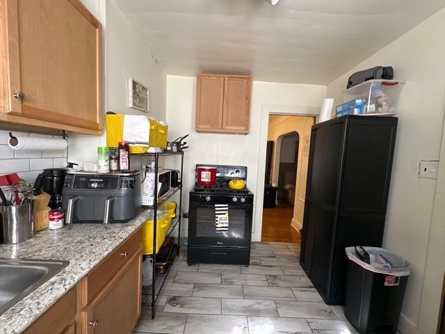 kitchen with decorative backsplash, sink, and black / electric stove