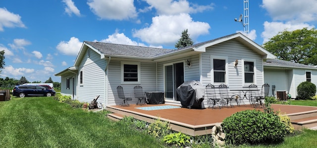 rear view of property featuring a yard and a wooden deck